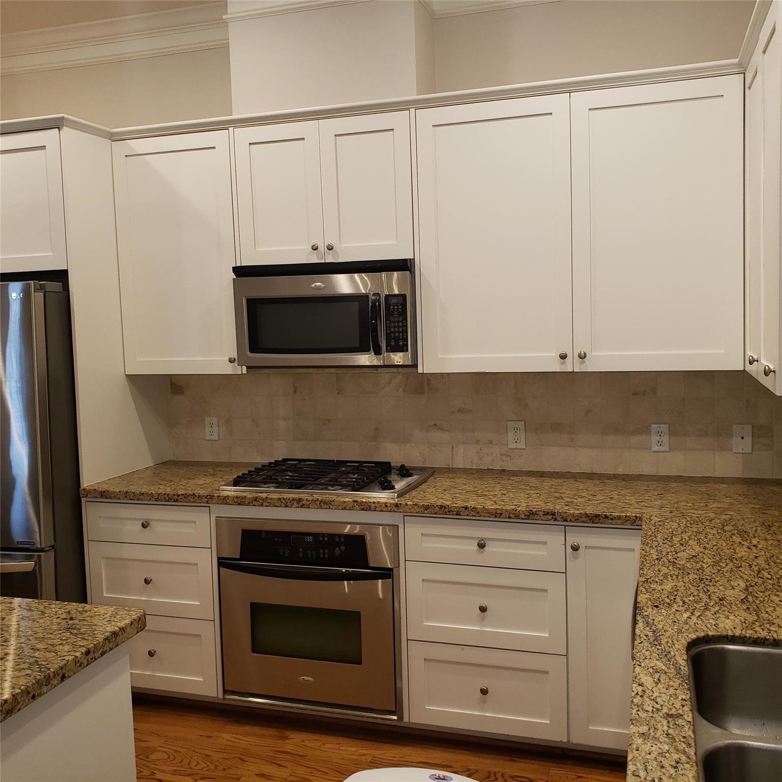 916 Lawrence Street, Unit C Houston, TX 77008 - Photo 11 of 38 a kitchen with granite countertop white cabinets stainless steel appliances and a counter space