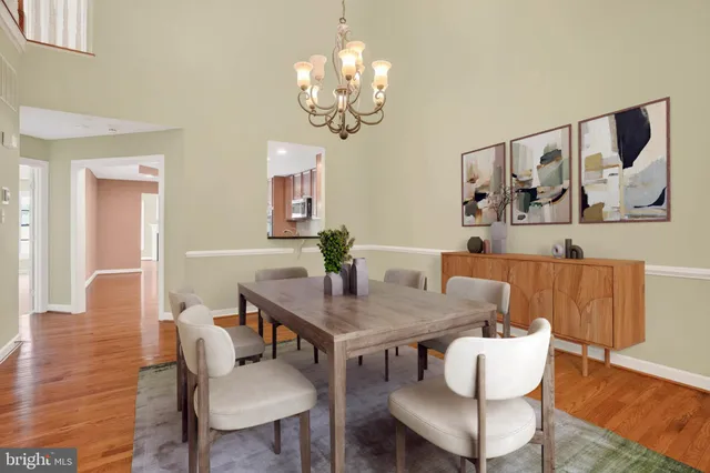 a kitchen with granite countertop a stove top oven a sink dishwasher a dining table and chairs with wooden floor