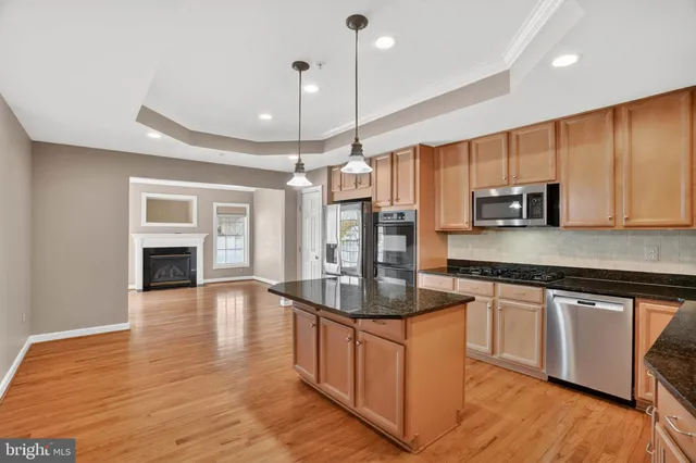a kitchen with stainless steel appliances a sink a stove a microwave cabinets and a counter top space