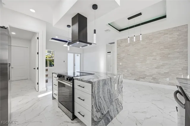 a kitchen with stainless steel appliances kitchen island granite countertop a refrigerator and a stove