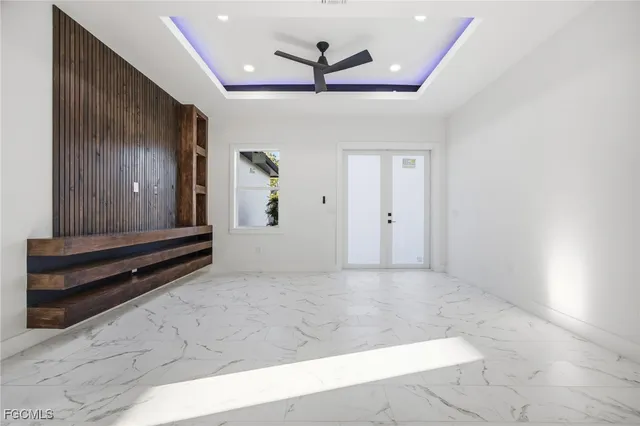 a view of a hallway with a ceiling fan and wooden floor