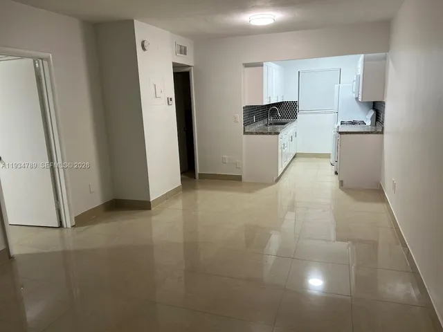 a view of kitchen with refrigerator sink and cabinets
