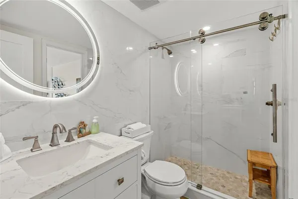 a bathroom with a toilet a sink a mirror and vanity