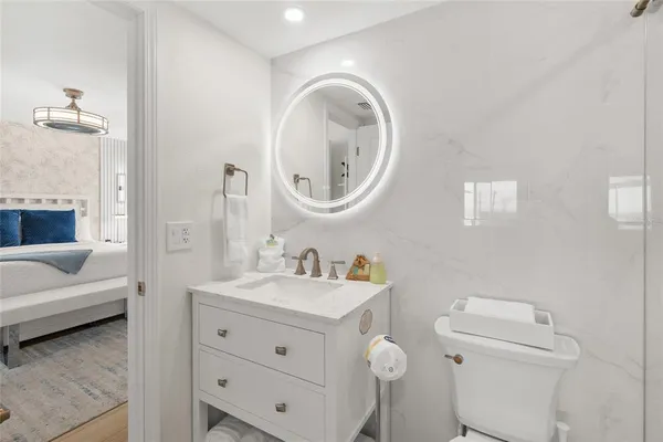 a en suite bathroom with a granite countertop sink and a mirror