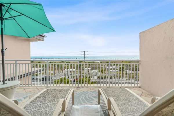 a view of a patio with a table and chairs under an umbrella