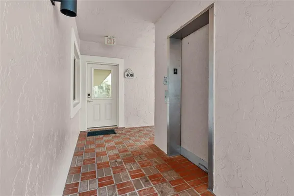a view of a hallway with wooden floor and windows in a room