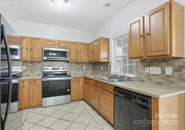a kitchen with stainless steel appliances granite countertop a sink stove and microwave