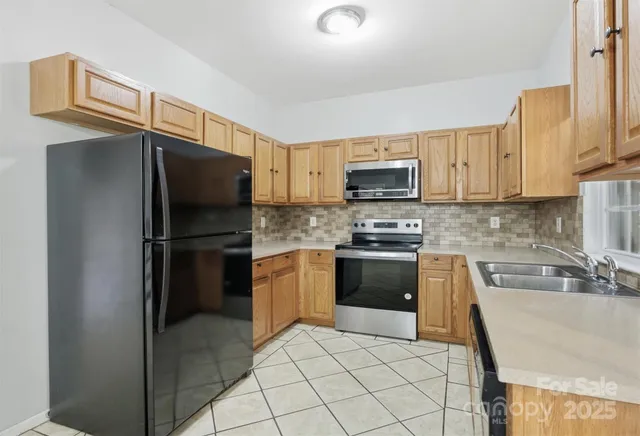 a kitchen with granite countertop a refrigerator and a stove top oven