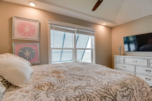 a bedroom with a bed and a flat screen tv in white walls