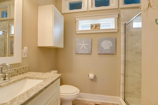 a bathroom with a granite countertop sink toilet and shower