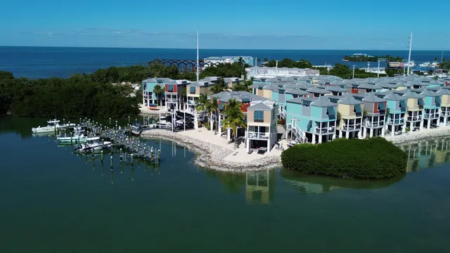 a view of ocean with boats and trees in all around