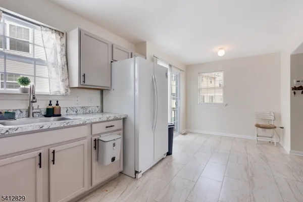 a view of a kitchen with a white stove top oven a sink and dishwasher with wooden floor