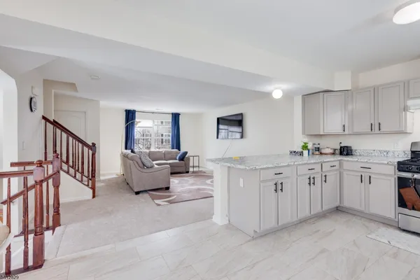 a large white open kitchen with stainless steel appliances granite countertop a lot of white cabinets