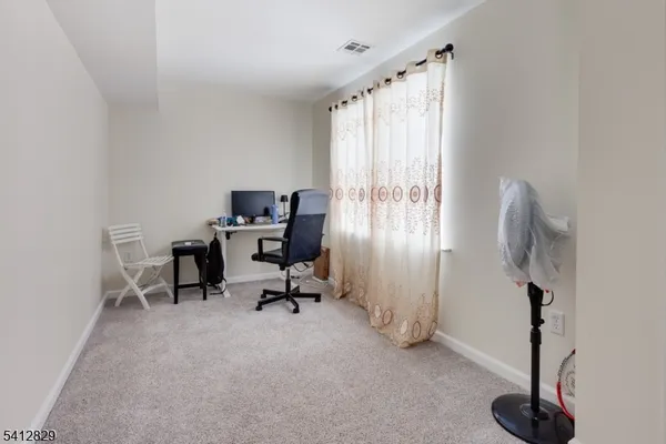 a view of a workspace with furniture and a window