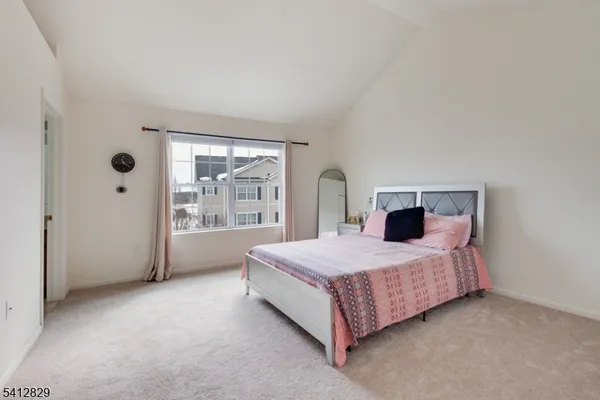 a spacious bedroom with a bed and window