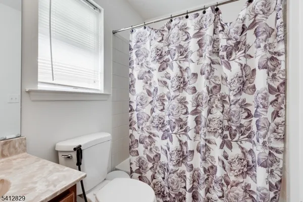 a white toilet sitting next to a shower curtain