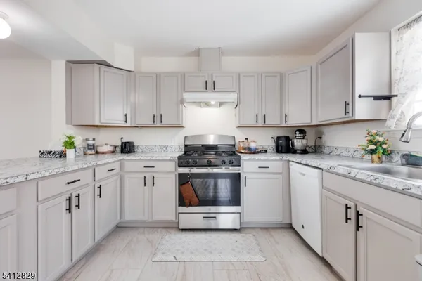 a kitchen with stainless steel appliances granite countertop a stove sink and cabinets