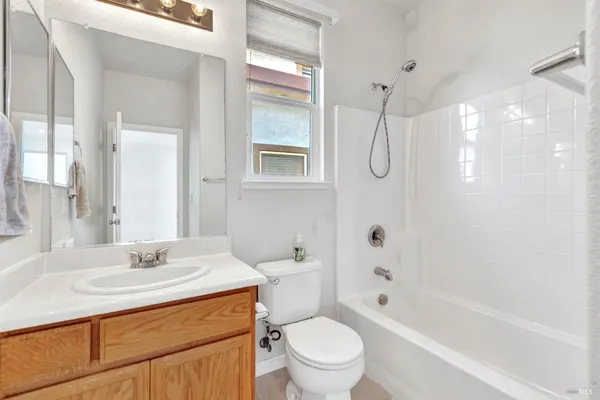 a bathroom with a granite countertop toilet a sink and a bathtub
