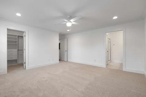 an empty room with closet and fan