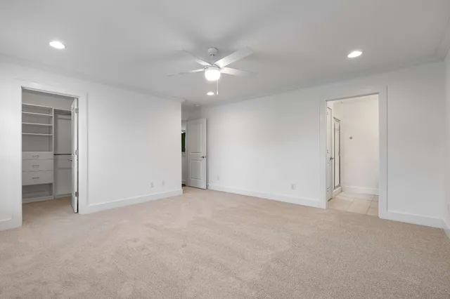 an empty room with closet and fan