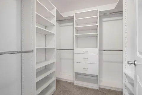a view of walk in closet with empty racks