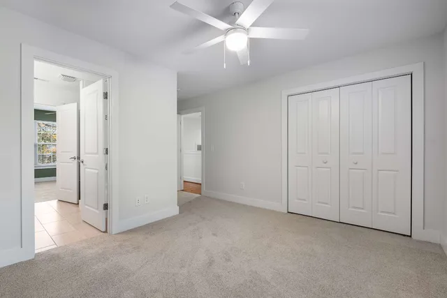 an empty room with closet and a ceiling fan