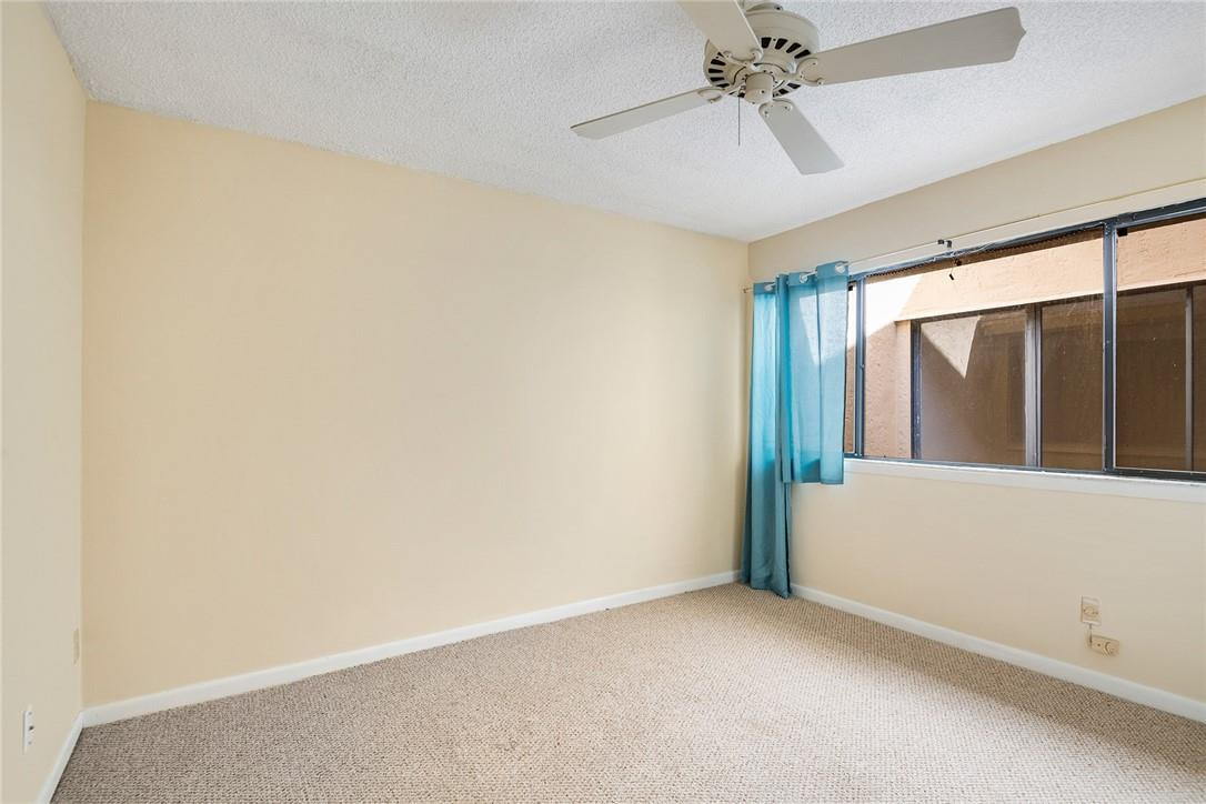 6535 Parkview Drive, Unit G Boca Raton, FL 33433 - Photo 14 of 27 an empty room with a ceiling fan and windows