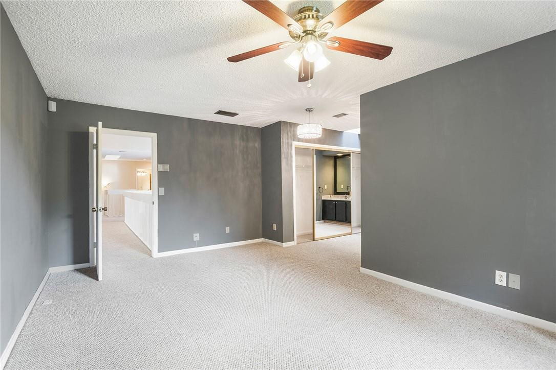 6535 Parkview Drive, Unit G Boca Raton, FL 33433 - Photo 17 of 27 an empty room with chandelier fan and kitchen view
