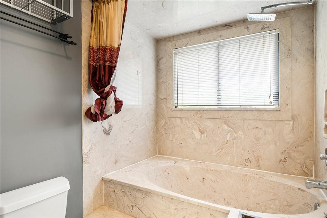 6535 Parkview Drive, Unit G Boca Raton, FL 33433 - Photo 19 of 27 a bath tub sitting next to a white sink and a toilet