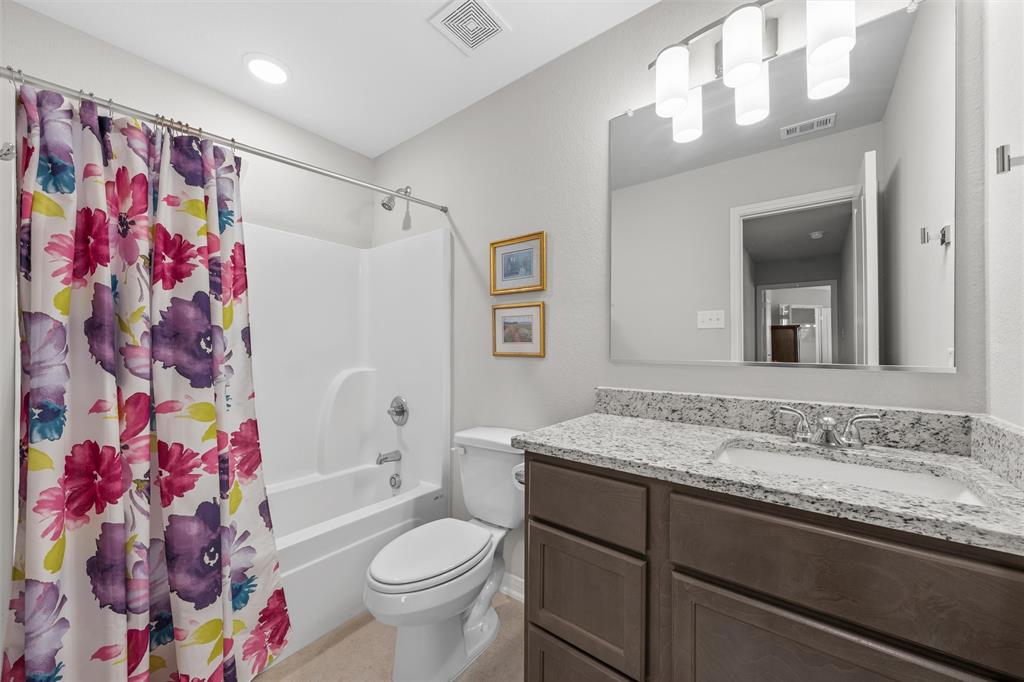 4056 Centerfire Road Waco, TX 76705 - Photo 19 of 27 a bathroom with a sink a toilet and shower curtain