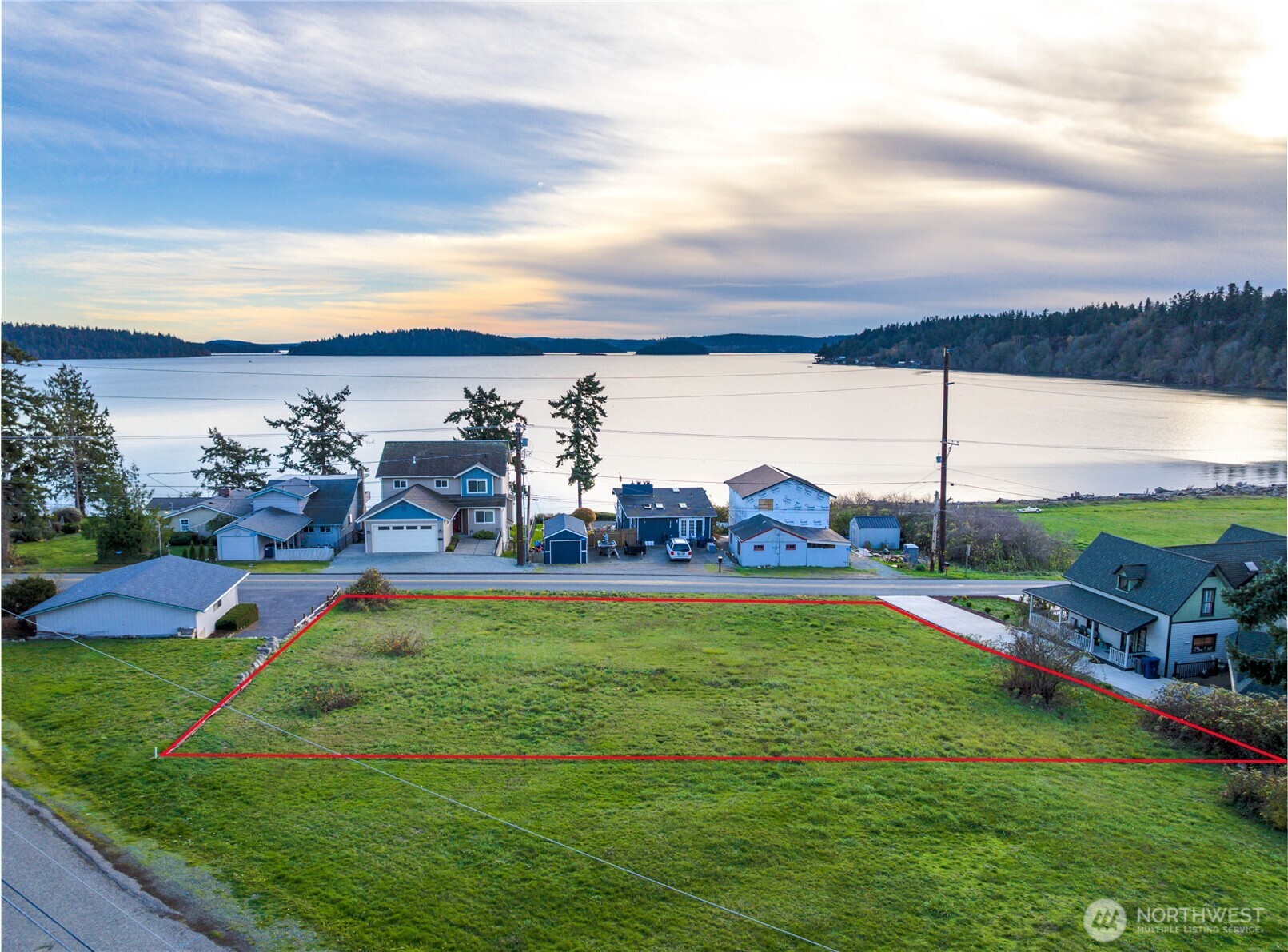 a view of a lake with a big yard and potted plants