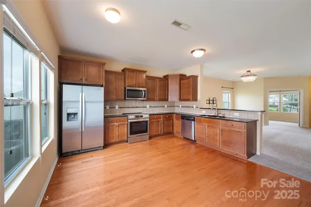 a large kitchen with a large counter top stainless steel appliances and cabinets