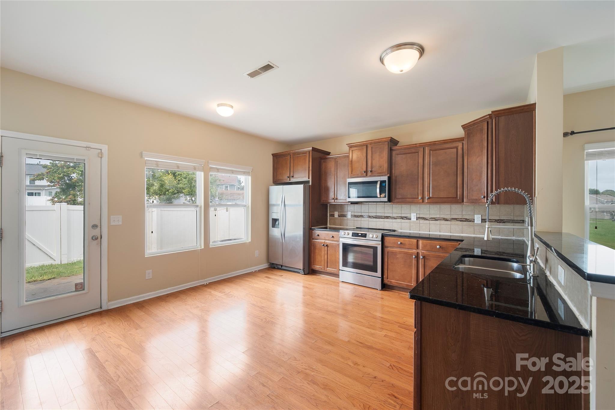 4720 Tradd Circle Monroe, NC 28110 - Photo 10 of 29 a kitchen with stainless steel appliances granite countertop a stove a sink and a refrigerator
