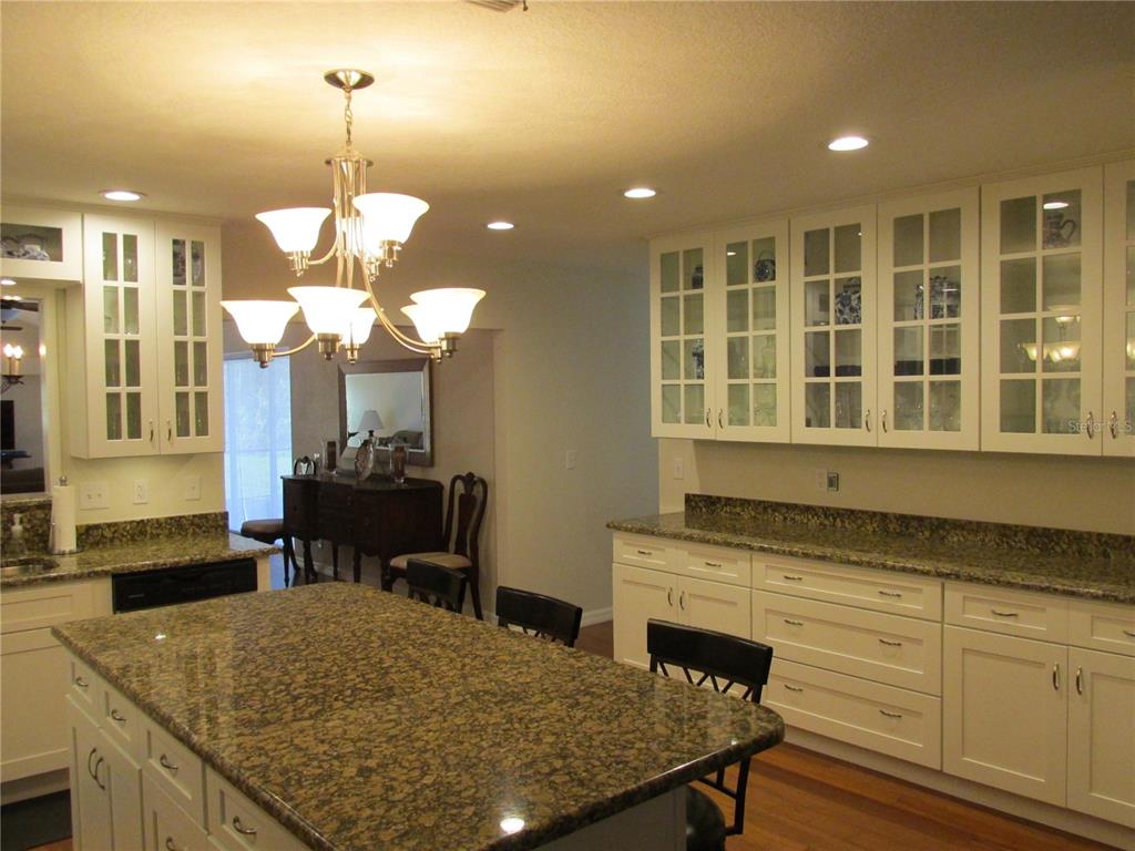 1767 Belvidere Road Englewood, FL 34223 - Photo 4 of 15 a kitchen with a kitchen island a stove and a chandelier