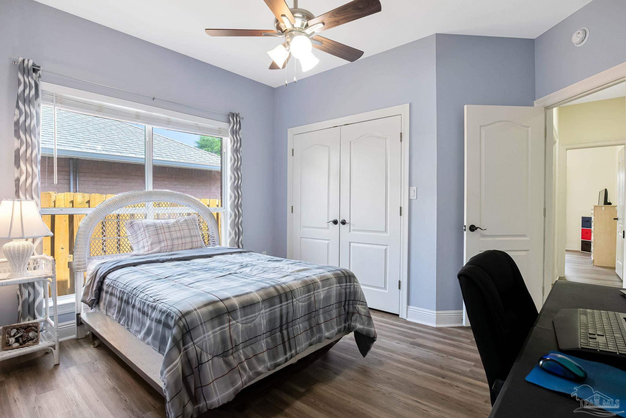 2822 Frederick Street Cantonment, FL 32533 - Photo 23 of 57 a bedroom with a bed a chair and a large window