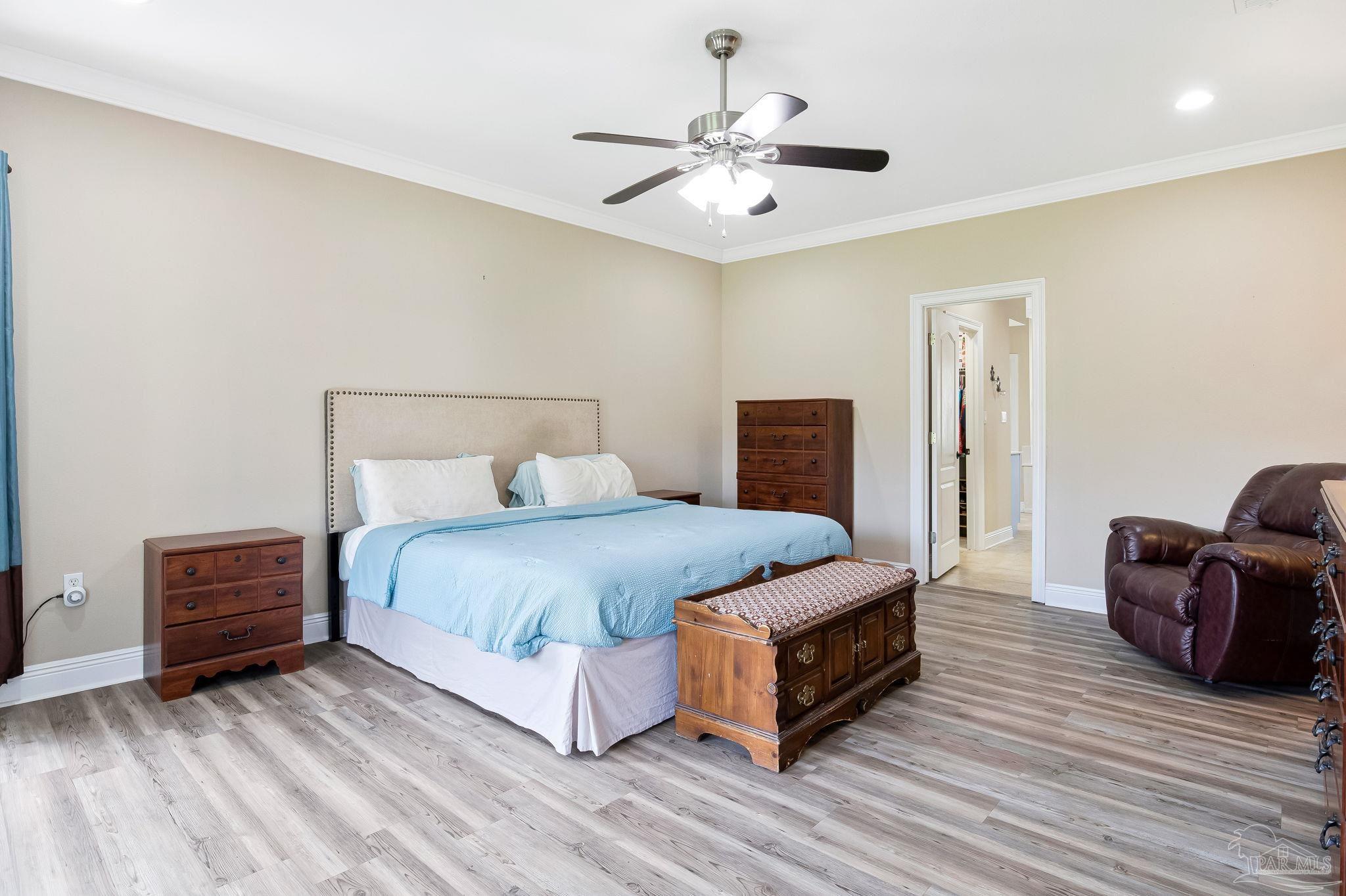 2822 Frederick Street Cantonment, FL 32533 - Photo 29 of 57 a spacious bedroom with a bed and a chandelier