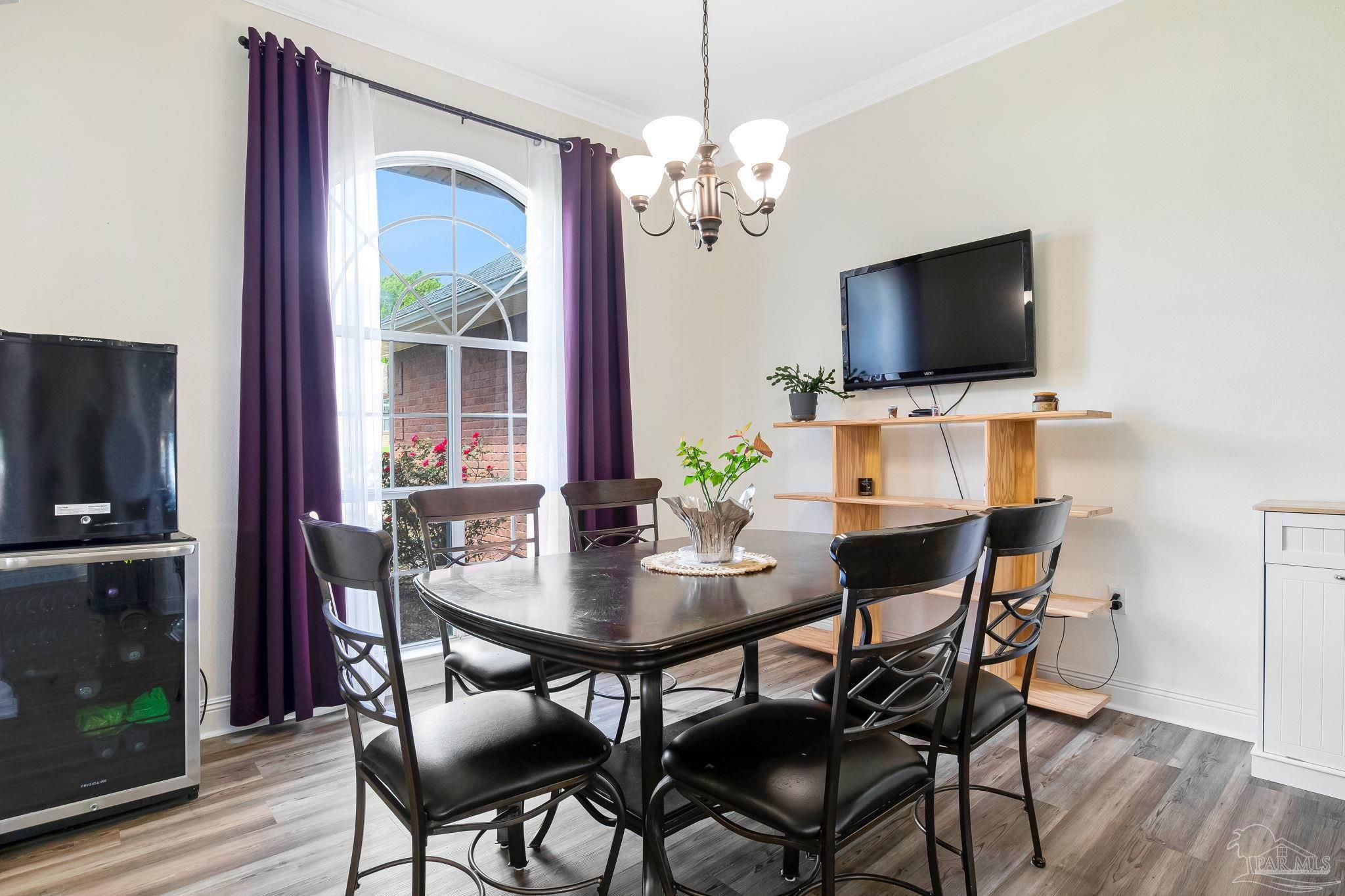 2822 Frederick Street Cantonment, FL 32533 - Photo 5 of 57 a dining room with furniture a chandelier and wooden floor