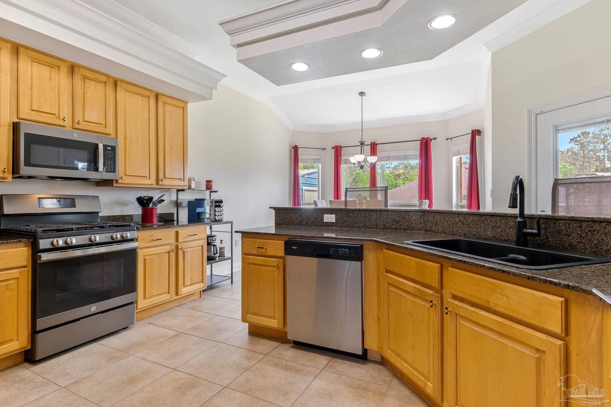 2822 Frederick Street Cantonment, FL 32533 - Photo 7 of 57 a kitchen with stainless steel appliances granite countertop a stove a sink and a microwave