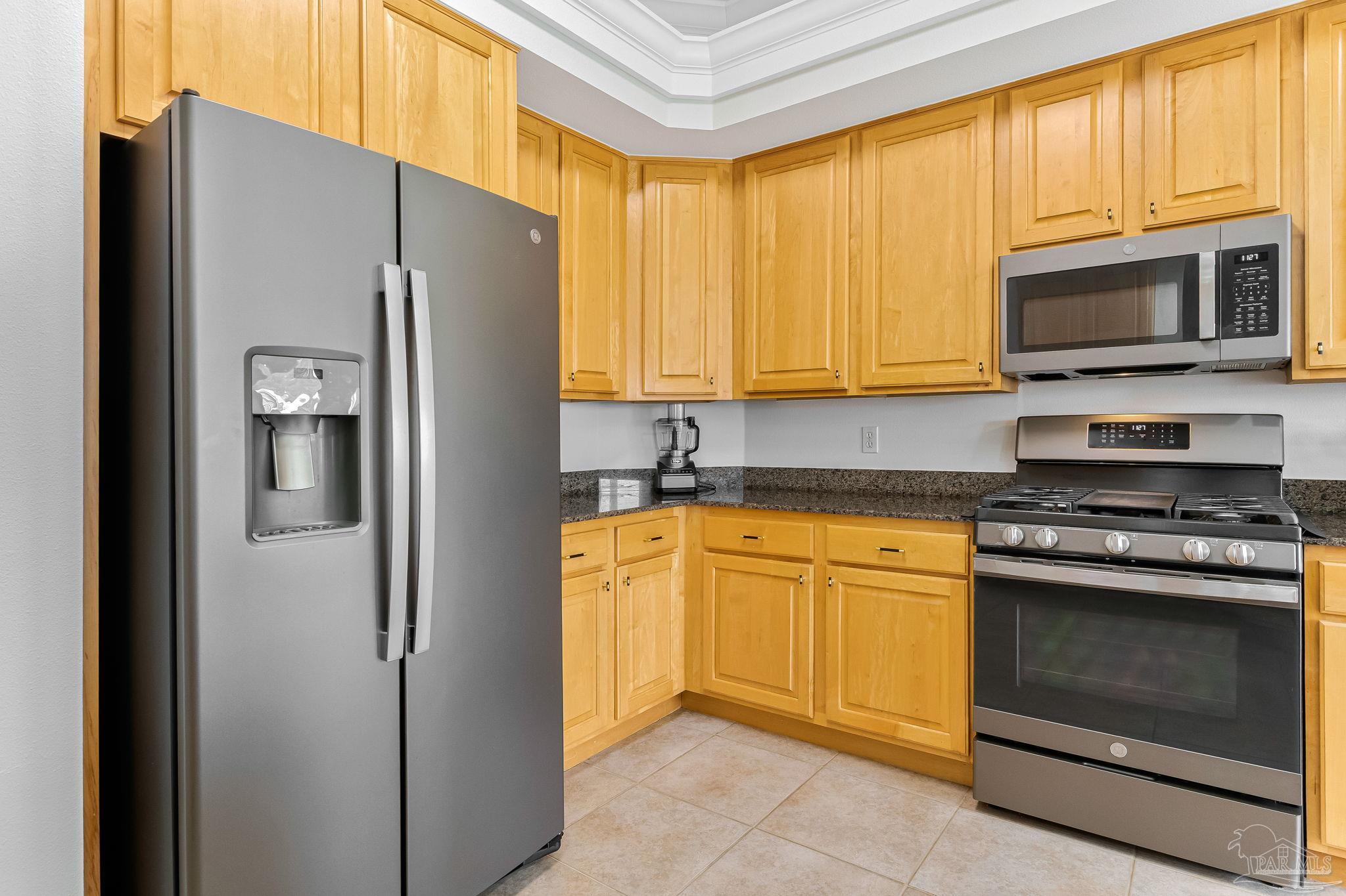 2822 Frederick Street Cantonment, FL 32533 - Photo 9 of 57 a kitchen with stainless steel appliances granite countertop a refrigerator stove and microwave