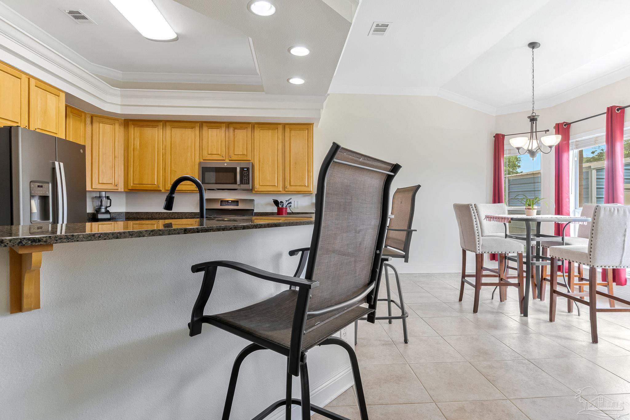 2822 Frederick Street Cantonment, FL 32533 - Photo 10 of 57 a kitchen with stainless steel appliances granite countertop sink microwave and refrigerator