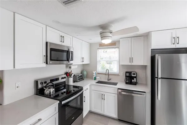 a kitchen with white cabinets and stainless steel appliances
