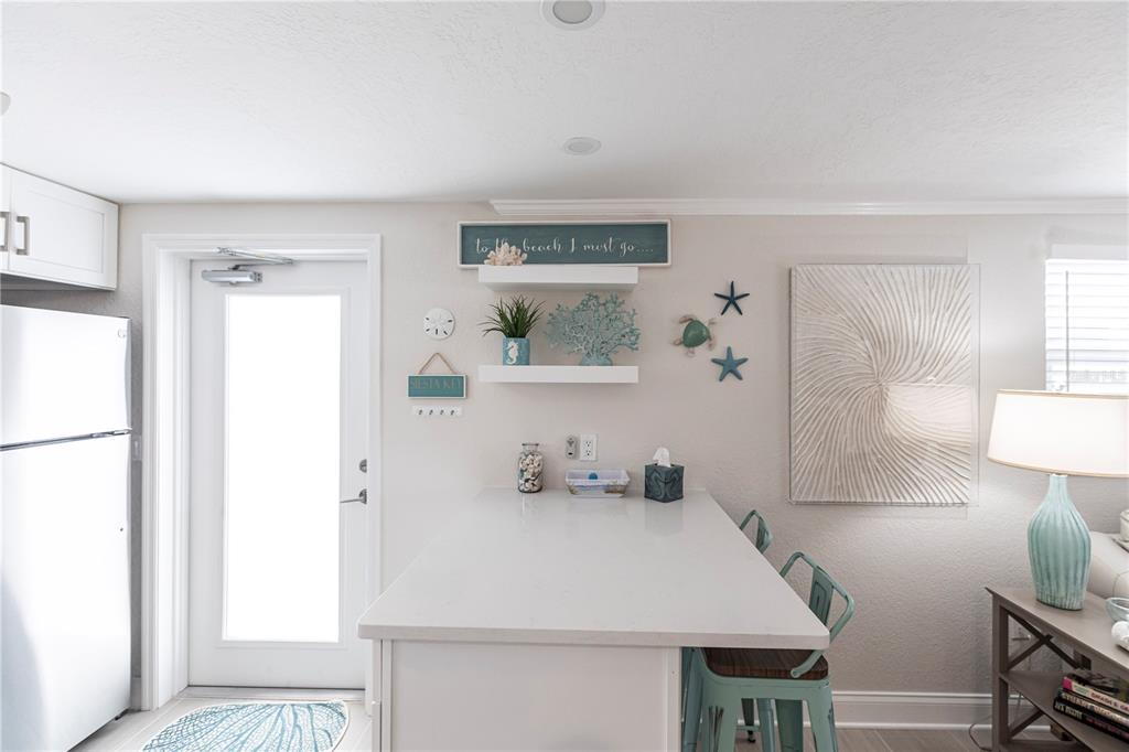 6154 Midnight Pass Road, Unit D15 Sarasota, FL 34242 - Photo 12 of 23 a view of kitchen island with furniture and wooden floor