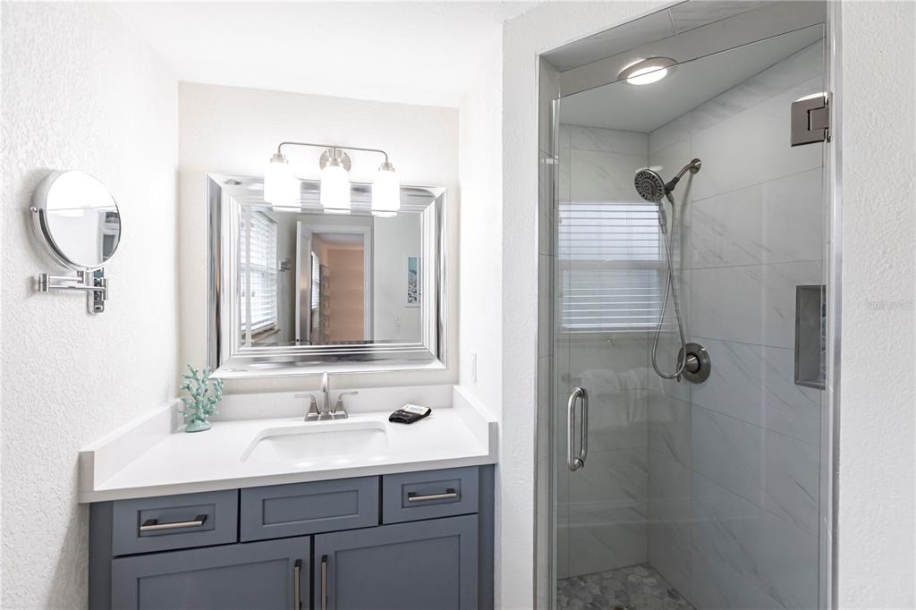6154 Midnight Pass Road, Unit D15 Sarasota, FL 34242 - Photo 16 of 23 a bathroom with a sink vanity granite and a mirror