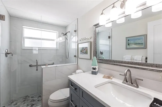 a bathroom with a sink toilet vanity and shower