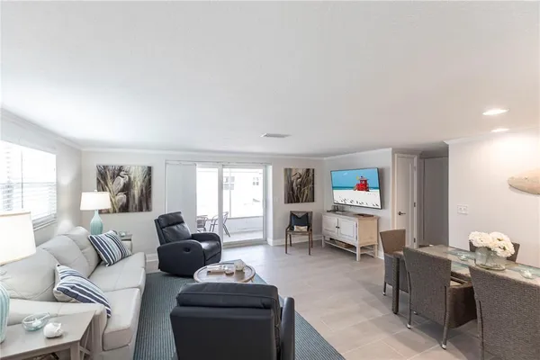 a living room with furniture a window and a flat screen tv
