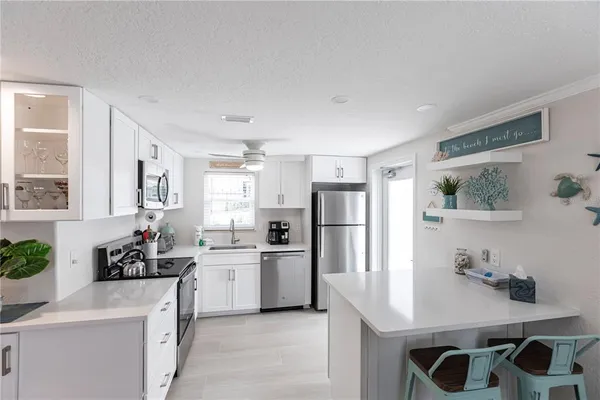 a kitchen with white cabinets and refrigerator