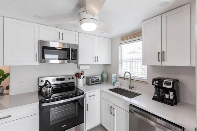a kitchen with cabinets stainless steel appliances and a window