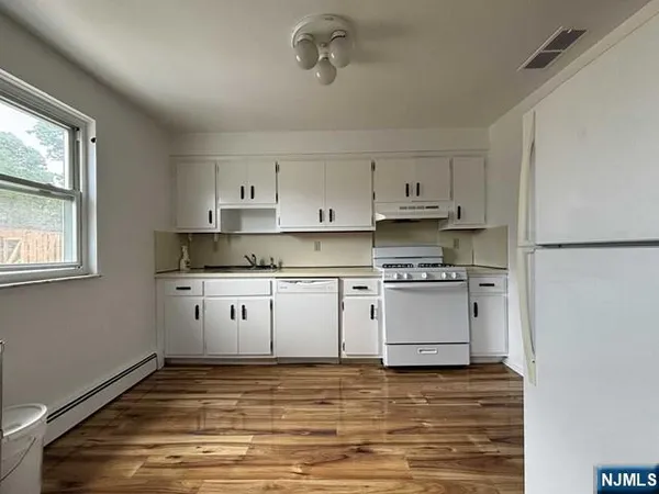 a kitchen with stainless steel appliances granite countertop a stove and white cabinets