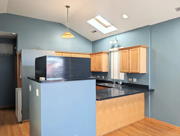 a kitchen with stainless steel appliances granite countertop a sink a stove and a refrigerator