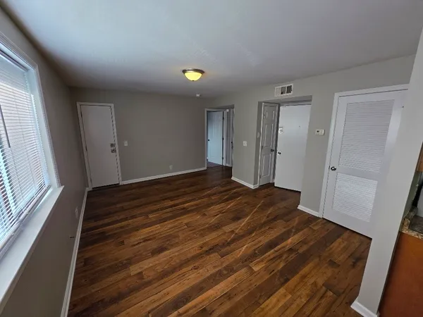 a view of a room with wooden floor and window